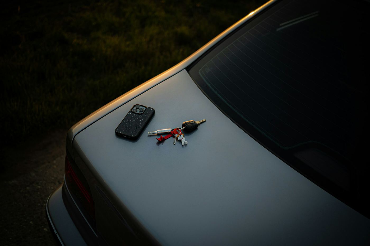 Car keys resting on the boot of a silver European saloon